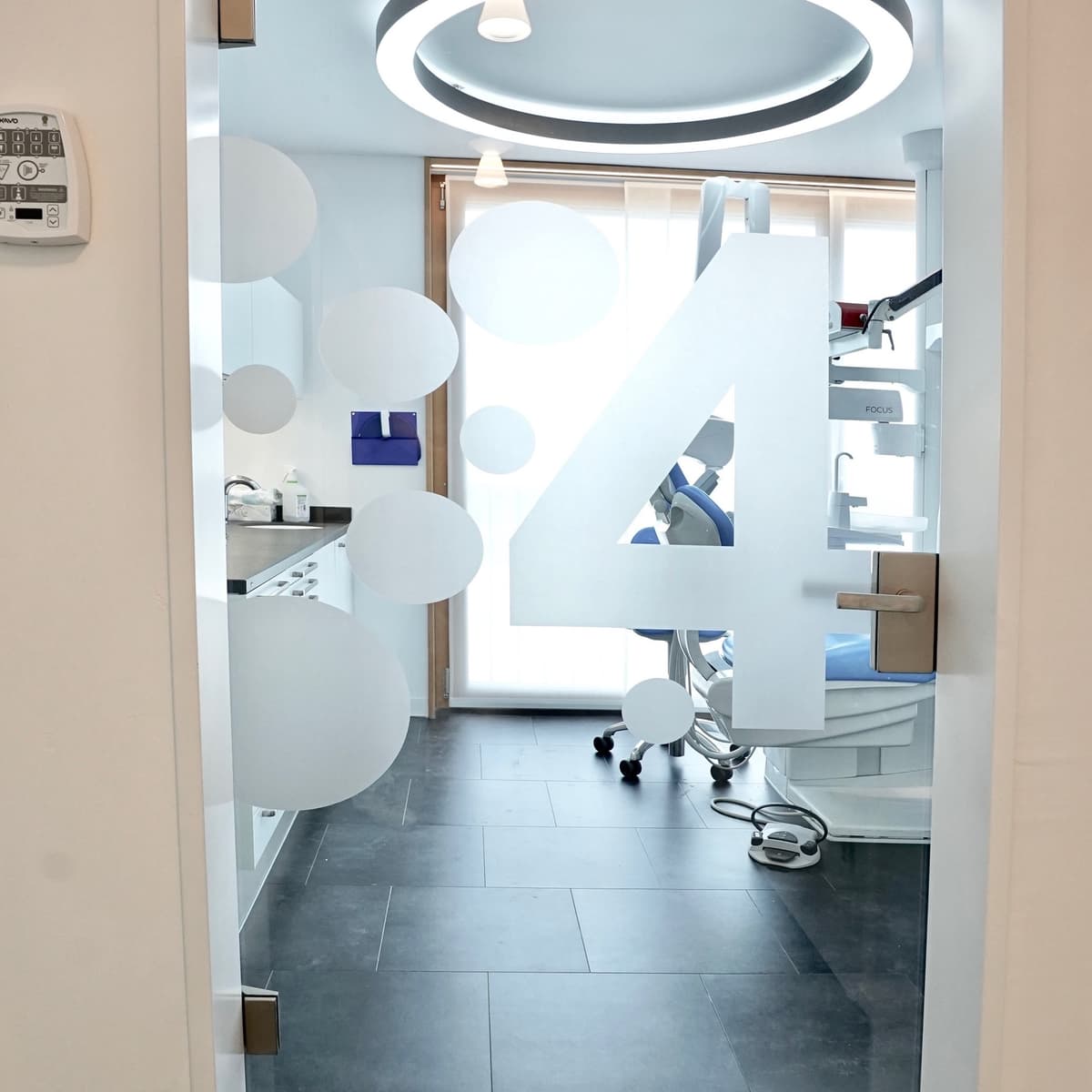 Behandlungszimmer mit moderner Ausstattung und Glastür